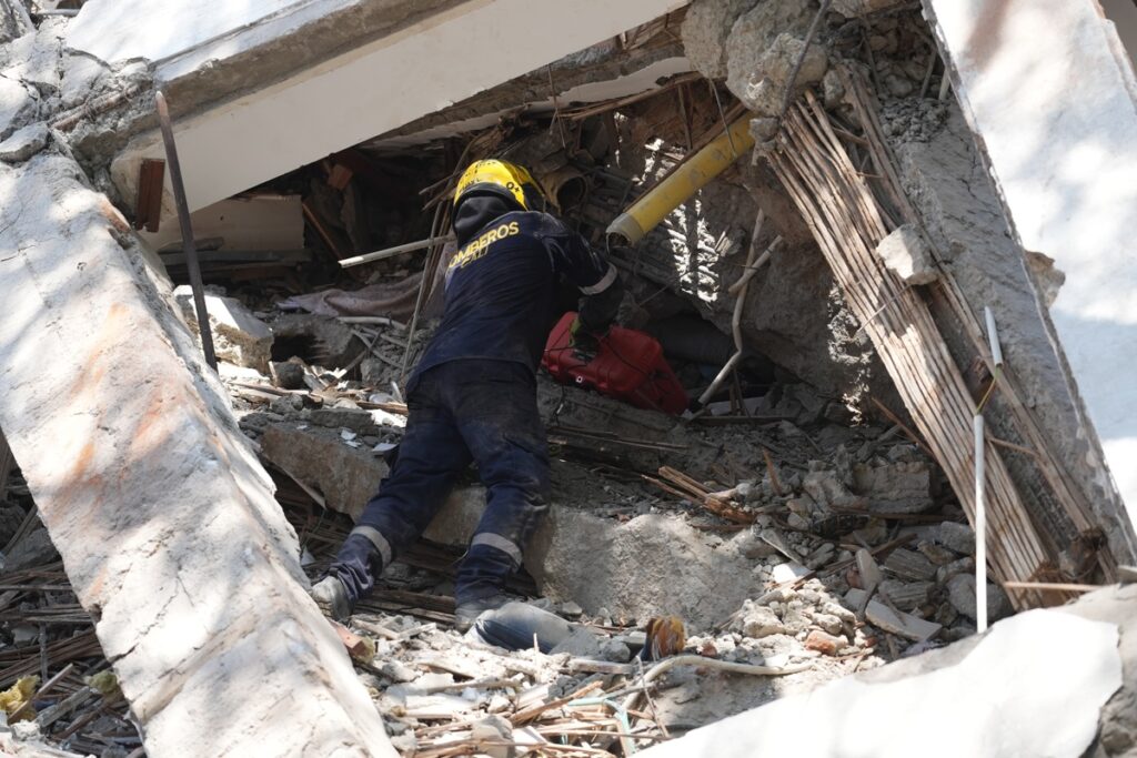 Un integrante del cuerpo de Bomberos de Cali trabaja entre los escombros de edificaciones colapsadas por el terremoto de magnitud 7,4 que sacudió esta mañana el país, este lunes en Cali (Colombia).