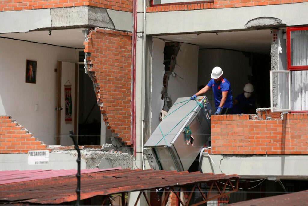 Un hombre retira un electrodoméstico de una edificación afectada por el terremoto de magnitud 7,4 en Cali (Colombia).