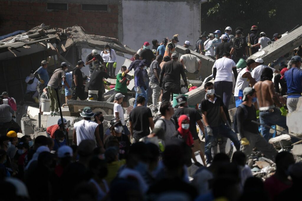 Personas trabajan en labores de rescate en una edificación colapsada por el terremoto de magnitud 7,4 que sacudió al país este lunes, en Cali (Colombia).