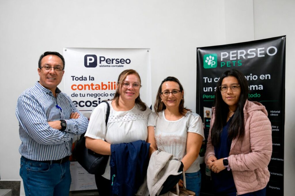 Cuatro asistentes al lanzamiento de Perseo Pets frente a banners de Perseo Soft.