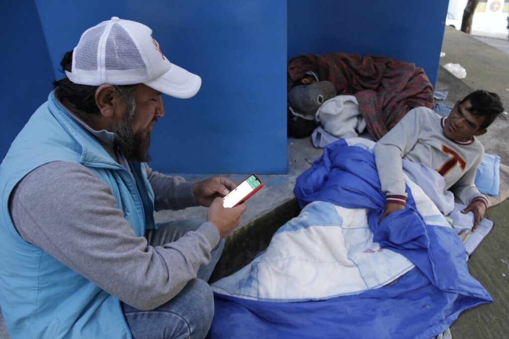 Personal del Patronato San José junto a un habitante de calle de Quito.