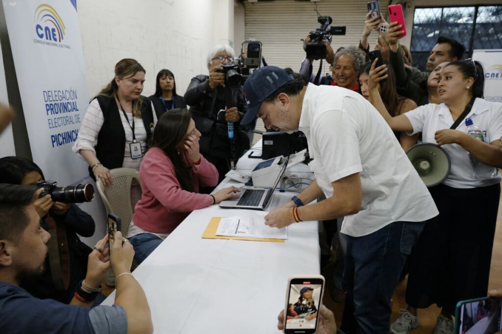 Pabel Muñoz firma documentos durante la inscripción de su candidatura a la Alcaldía de Quito ante el CNE.