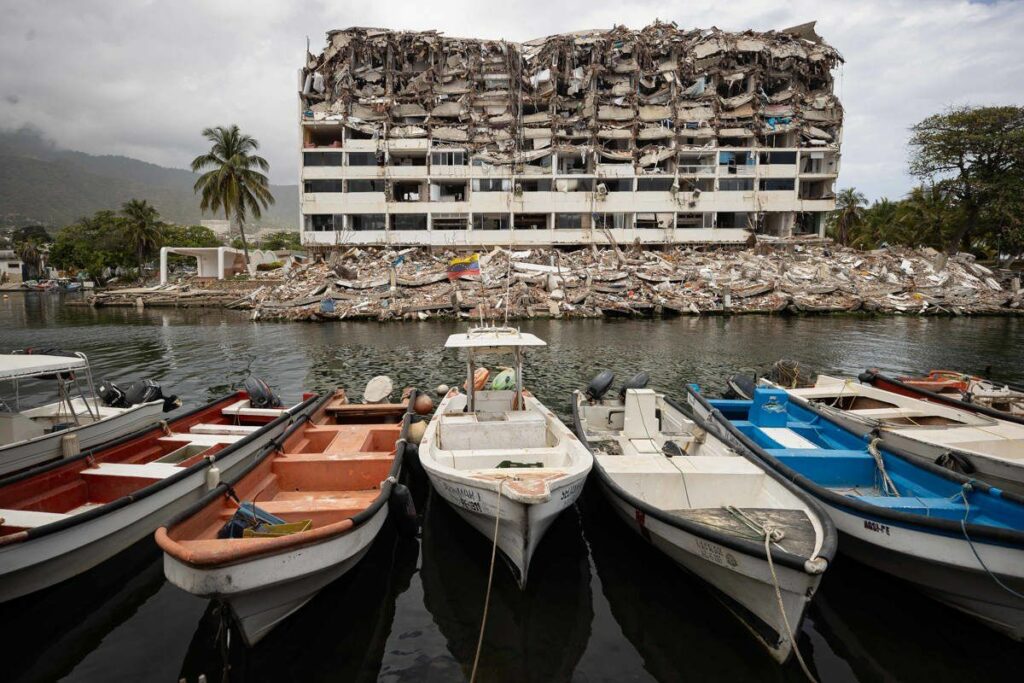 Fotografía que muestra varias embarcaciones frente a un edificio colapsado por los terremotos del 24 junio, este domingo en La Guaira (Venezuela).