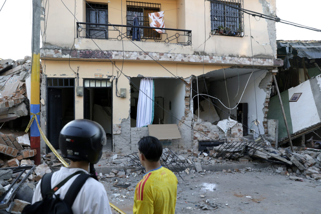 Personas observan los escombros de una vivienda en el sector de Corocito en Pereira (Colombia), luego del terremoto de 7,4 grados.