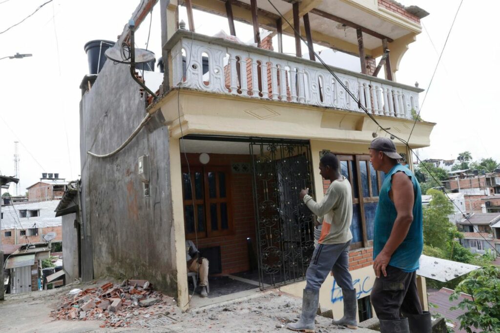 Personas observan una casa afectada tras el terremoto en Quibdó (Colombia).