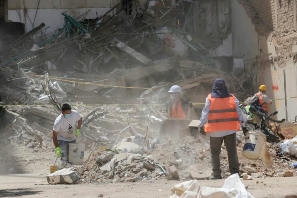 Personas recogen escombros de una edificación destruida por el terremoto cerca a la Plaza de Bolívar de Pereira.
